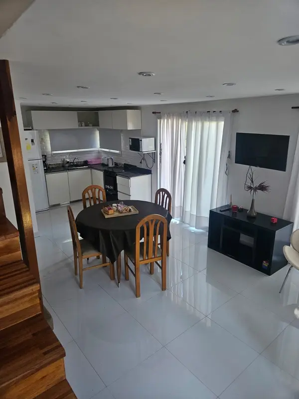Living comedor de la cabaña Mar, con mesa redonda y cocina integrada